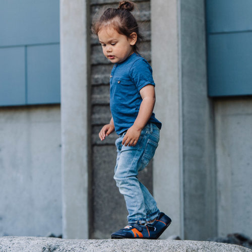 A toddler wearing a pair of blue Denny's children's barefoot shoes by Jack & Lily