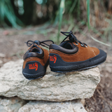A rear view of Sole Runner Pan children's minimalist shoe on rocks in nature warm winter barefoot shoe